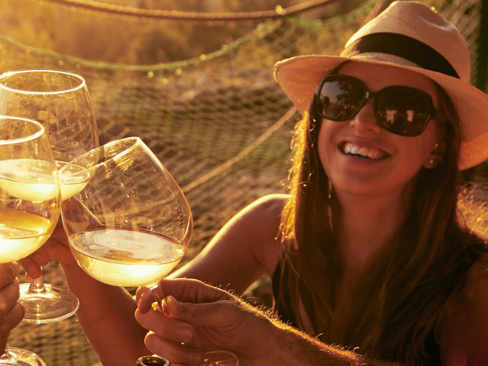 妇女与朋友享用白葡萄酒。Expancel Microshes是微凝聚和合成葡萄酒软木塞中的优异添加剂。